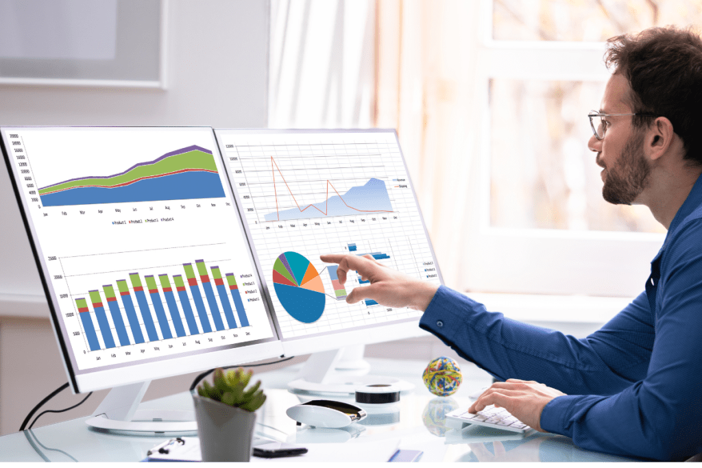 A man pointing at a graph on a computer screen.