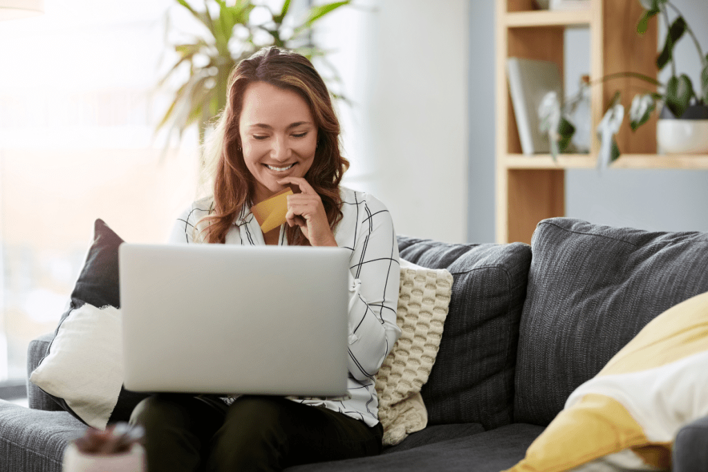 A woman sitting on a couch using a laptop.