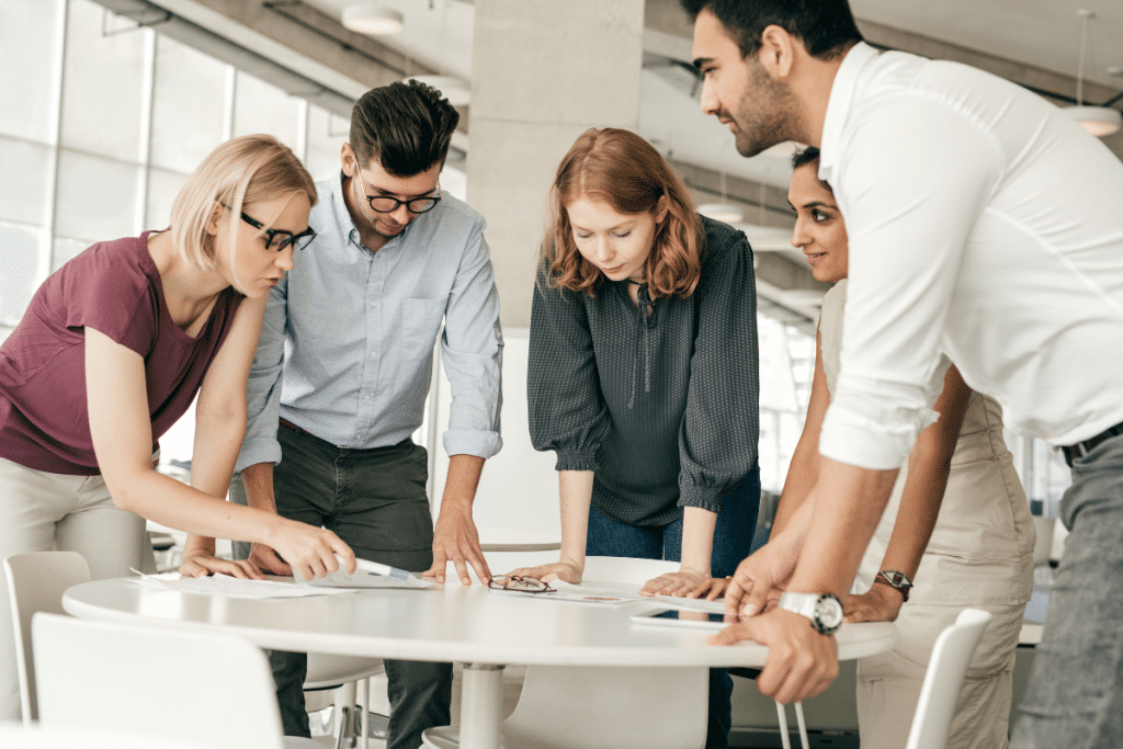 A group of business people standing around a table.