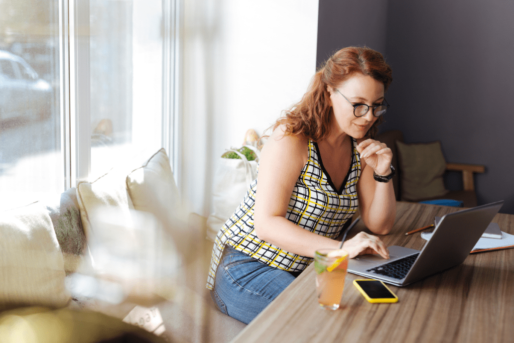 A woman sitting at a table with a laptop.