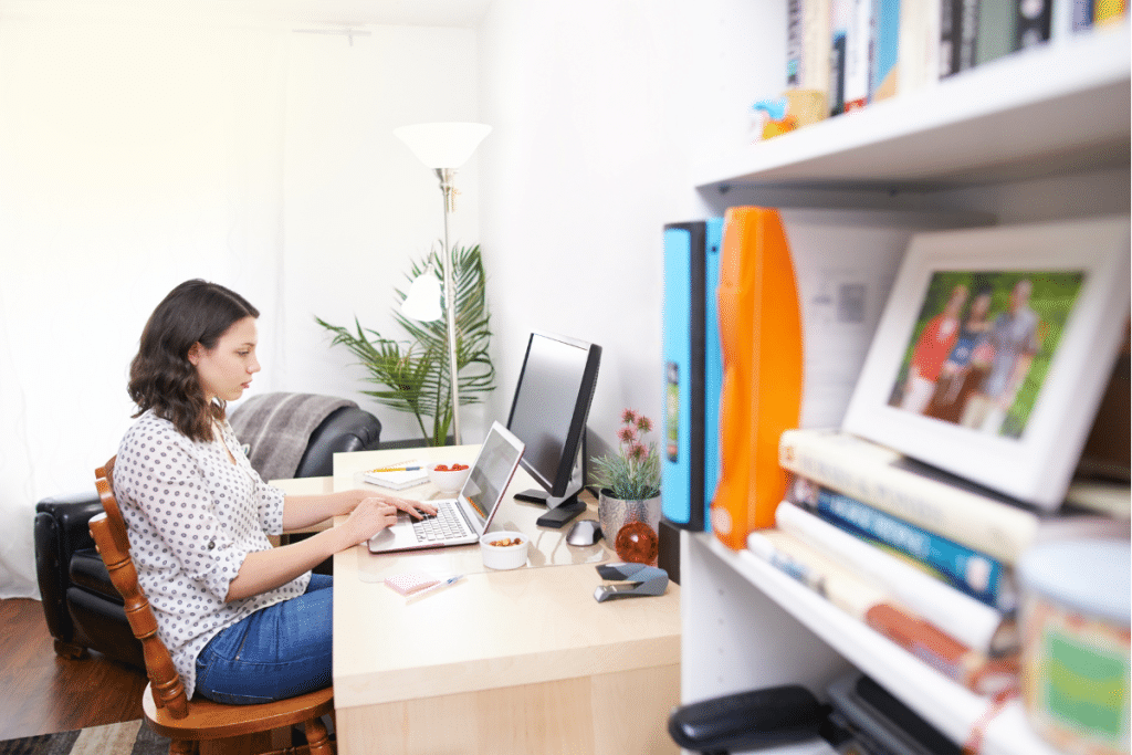 A woman working on her laptop in her home office.